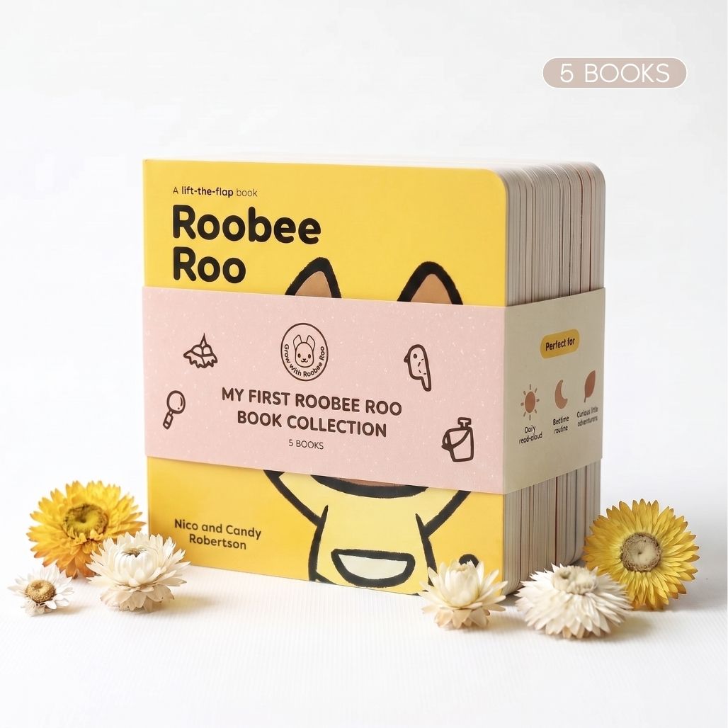 A children's book collection titled 'Roabee Roo' with a yellow cover, wrapped in a pink paper band reading 'MY FIRST ROOBEE ROO BOOK COLLECTION' and '5 BOOKS.' The set is photographed on a white background with decorative dried flowers around it.